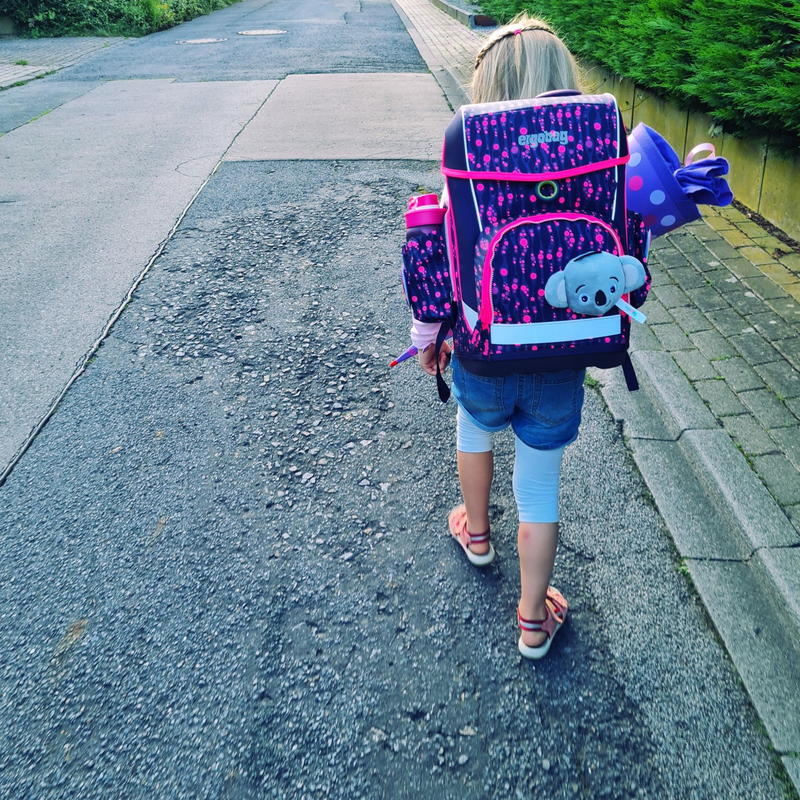 Ein Mädchen mit einer Schultüte auf dem Weg zur Schule